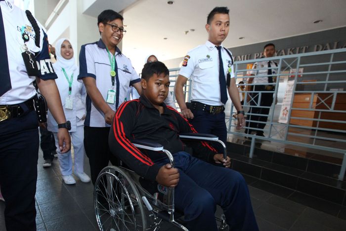 Arya Permana, bocah obesitas asal Karawang diantar sejumlah petugas yang merawatnya meninggalkan rumah sakit seusai menjalani operasi plastik tahap pertama mengangkat kulit menggelambir di kedua lengannya, di Rumah Sakit Hasan Sadikin (RSHS), Jalan Pasteur, Kota Bandung, Jawa Barat, Senin (29/7/2019