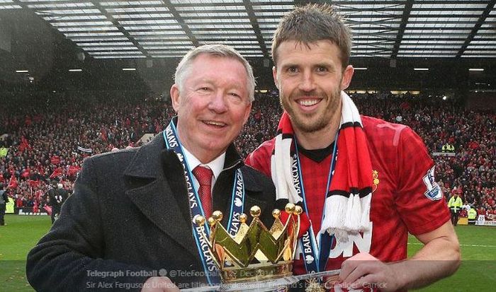 Legenda Manchester United, Michael Carrick, mengangkat trofi juara Liga Inggris musim 2012-2013 bersama pelatih Sir Alex Ferguson.