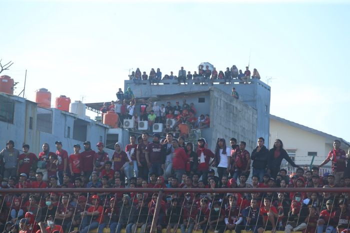 Suporter PSM Makassar yang tidak dapat menonton timnya secara langsung di Stadion Mattoangin, Makassar pada Selasa (6/8/2019). Mereka akhirnya memanjat atap gedung agar dapat mennyaksikan tim kesayangannya bertanding.