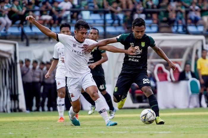 Bek Madura United, Guntur Ariyadi, berduel dengan winger Persebaya Surabaya, Osvaldo Haay, pada laga pekan ke-13 Liga 1 2019.