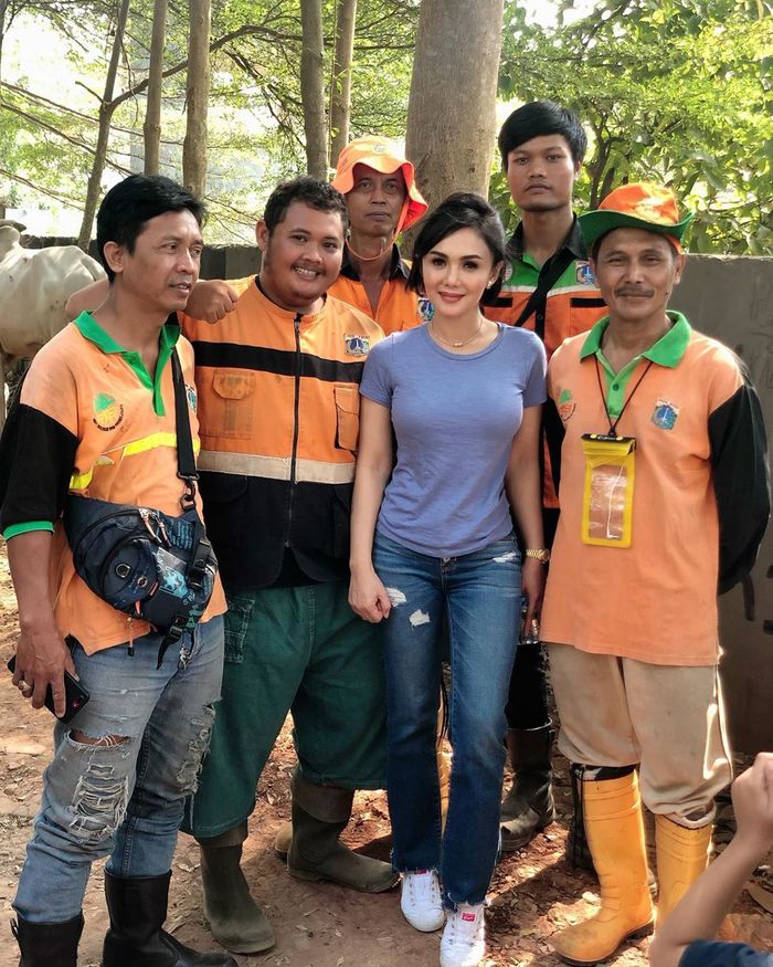 Yuni Shara saat foto bersama petugas berseragam oranye.