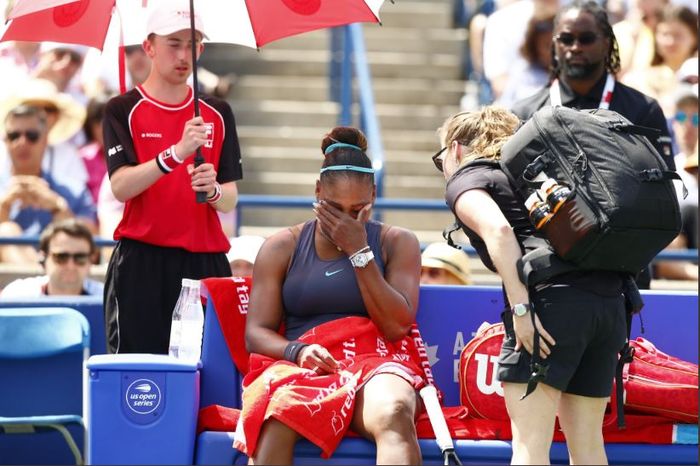 Serena Williams (duduk) saat memutuskan untuk mengundurkan diri pada laga final Rogers Cup 2019, Minggu (11/8/2019) waktu setempat