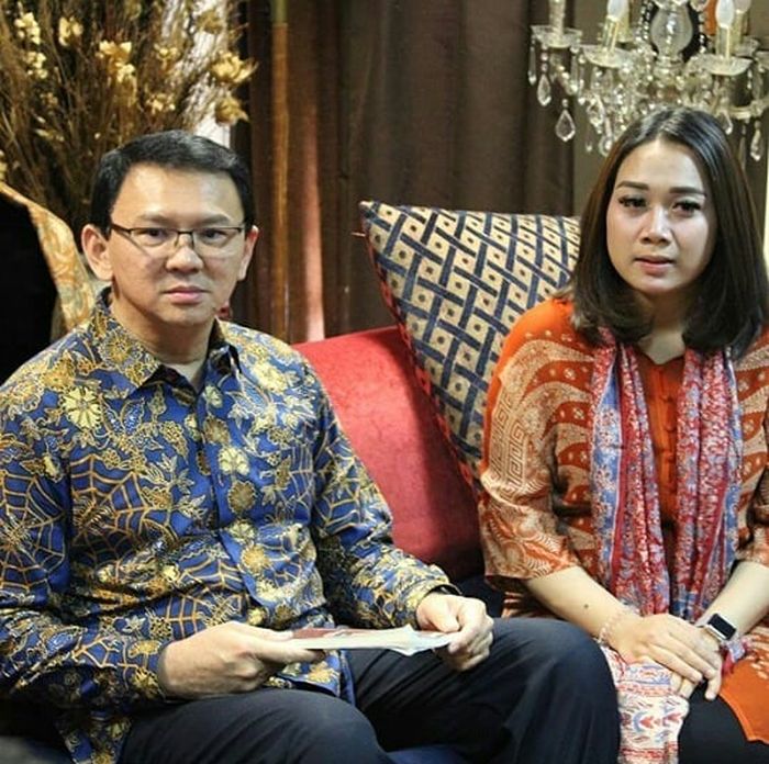 Potret Puput Nastiti Devi saat mengenakan tunik batik oranye dengan padanan syal batik