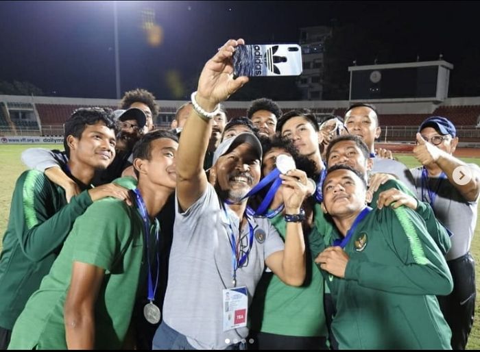 Pelatih Timnas U-18 Indonesia Fakhri Husaini (tengah) berswafoto dengan para pemainnya usai menerima medali peringkat ketiga Piala AFF U-18 2019 di Vietnam, Senin (19/8/2019).