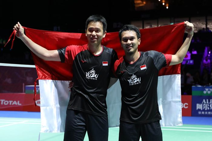 Pasangan ganda putra Indonesia, Hendra Setiawan dan Mohammad Ahsan, berpose dengan bendera Merah Putih usai memenangi medali emas Kejuaraan Dunia 2019 di Basel, Swiss, Minggu (25/8/2019).