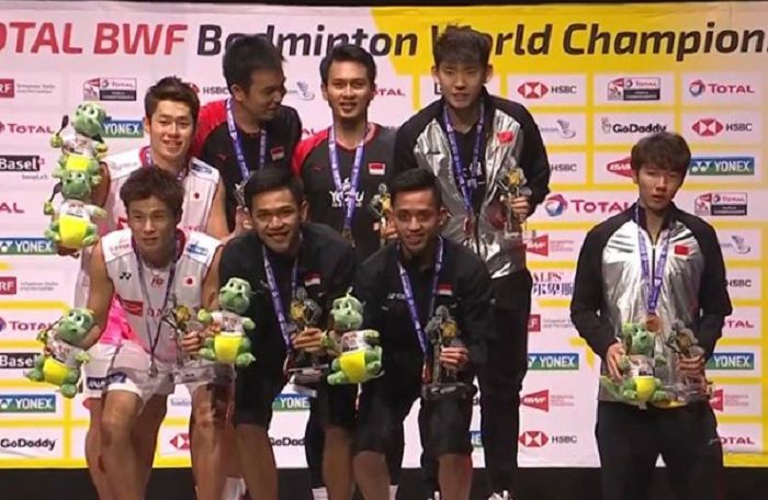 Momen Li Junhui (paling kanan) yang tak turut serta naik diatas podium juara Ahsan/Hendra di Kejuaraan Dunia 2019.