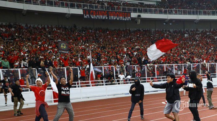 Aksi suporter Timnas Indonesia yang memasuki lapangan pada ajang kualifikasi Piala Dunia Qatar 2022 di Stadion Utama Gelora Bung Karno, Jakarta, Kamis (5/9/2019).