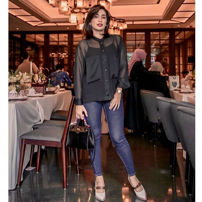 Ussy Sulistiawaty mengenakan kemeja beraksen sheer alis transparan