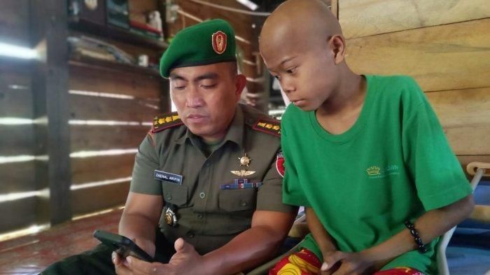 Dandim 1414 Tana Toraja, Letkol Czi Zaenal Arifin saat memperlihatkan foto-foto Almarhum anaknya saat mengunjungi Fadly (16) setelah diamputasi di rumahnya, Lembang (Desa) Rantedada Kecamatan Mengkendek, Kabupaten Tana Toraja, Sulawesi Selatan, Kamis (19/9/2019) kemarin sore.