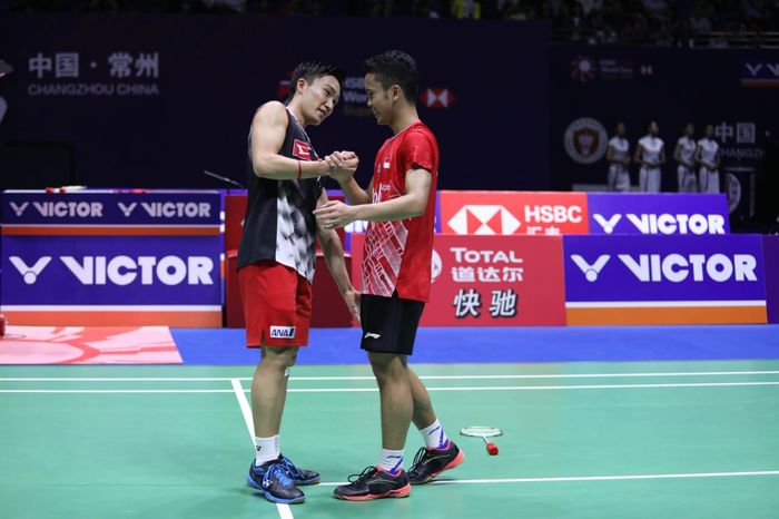 Pebulu tangkis tunggal putra Indonesia, Anthony Sinisuka Ginting (kanan), bersalaman dengan Kento Momota (Jepang) yang menjadi rivalnya pada final China Open 2019.