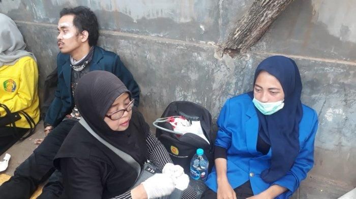 Elis Erna Wati sedang menolong mahasiswi yang terluka