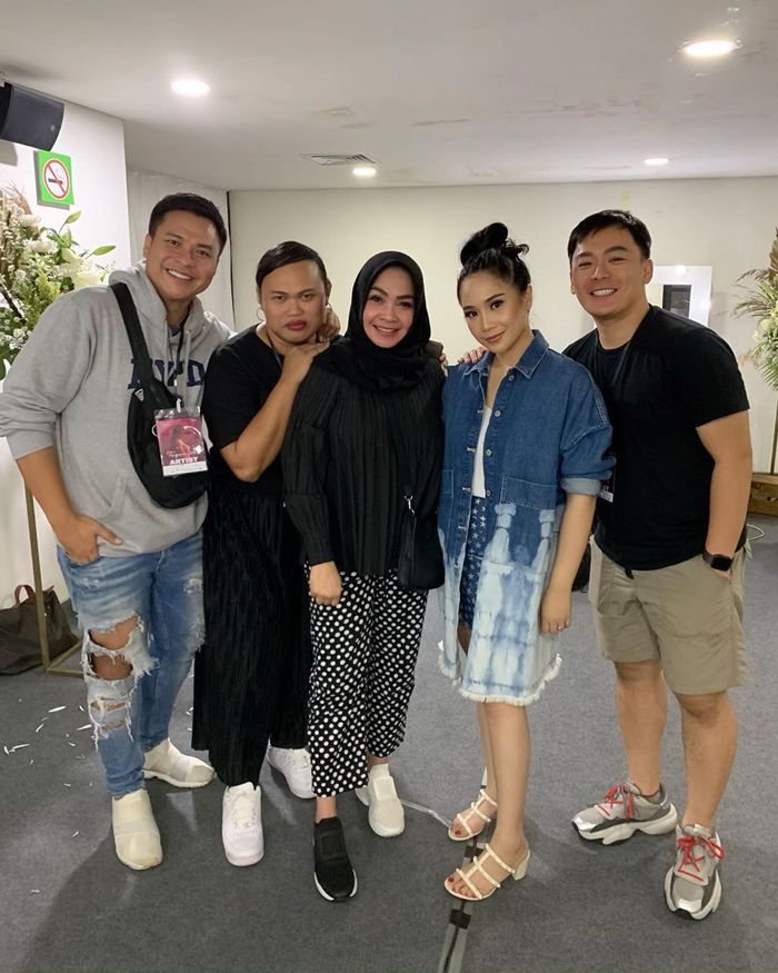 Rieta Amilia mengenakan sepatu sneakers beda warna