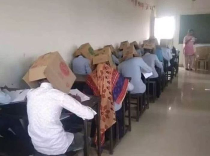Para mahasiswa dan mahasiswi mengenakan kardus bekas di kepala mereka