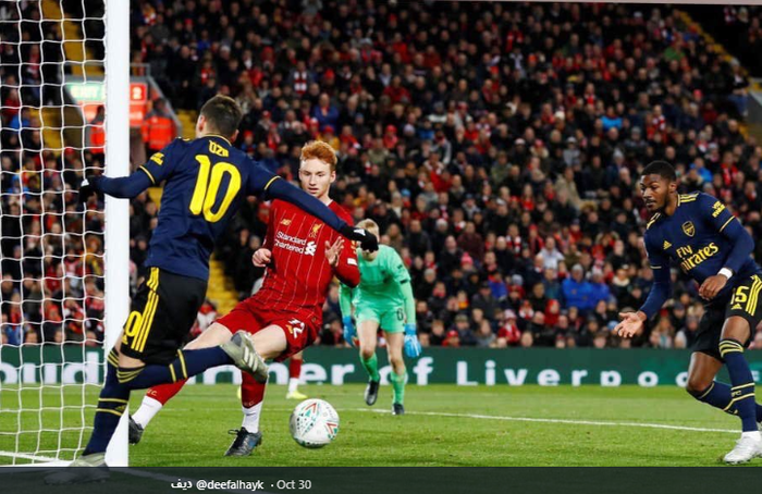 Mesut Oezil saat memberikan umpan back-heel kepada Ainsley Maitland-Niles yang berujung gol keempat Arsenal saat kontra Liverpool di EFL Carabao Cup