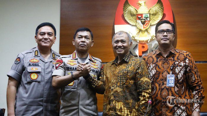Ketua KPK Agus Rahardjo berjabat tangan dengan Kapolri Jenderal Pol Idham Azis disaksikan oleh Kadivhumas Mabes Polri M Iqbal (kiri) dan Jubir KPK Febri Diansyah (kanan) usai mengadakan pertemuan tertutup di gedung KPK, Jakarta, Senin (4/11/2019). 