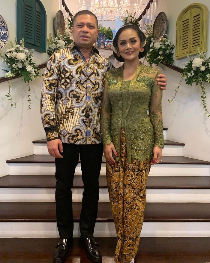 Krisdayanti terlihat mengenakan kain motif batik bernuansa warna cokelat keemasan untuk bawahannya