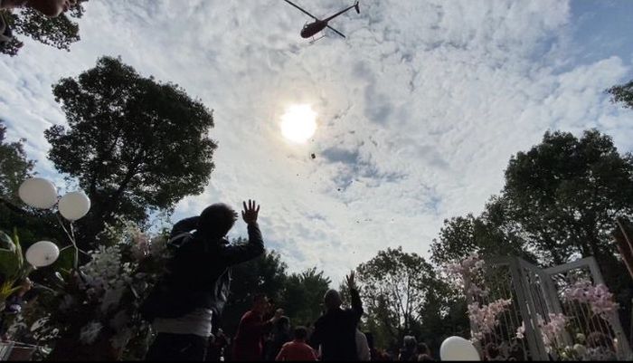 Helikopter tersebut menaburkan bunga di atas pernikahan itu.