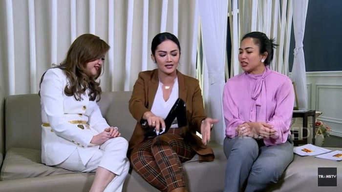 Krisdayanti menunjukkan sepatu kerjanya kepada Feni Rose.