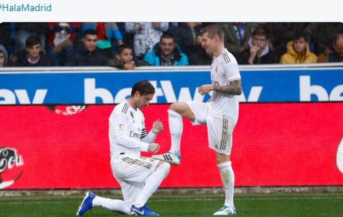 Bek Real Madrid, Sergio Ramos, melakukan selebrasi dengan menyemir sepatu Toni Kroos dalam laga Liga Spanyol melawan Deportivo Alaves di Estadio de Mendizorroza, Sabtu (30/11/2019).