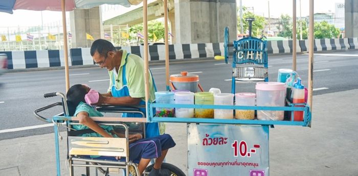 Paman Dam dan putranya ketika berjualan di pinggir jalan kota Bangkok.