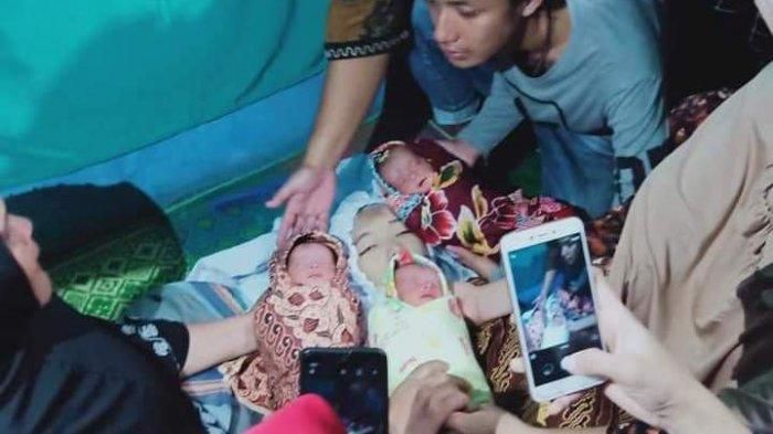 Dina Nasution yang tampak seperti tersenyum dan 3 bayi kembarnya.