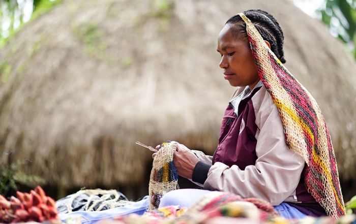 Salomina Pabika menyelesaikan pembuatan noken di Jalan Anelagak Hotel Jerman, Kampung Yumugima, Distrik Siepkosi, Kabupatten Jayawijaya, Papua. Salomina merupakan salah satu penggerak masyarakat perempuan di Kelompok Kerajinan Noken Humi Soge yang memproduksi noken dan mengembangkannya menjadi produk lain diantaranya penutup kepala, rok, baju, gendongan anak bahkan gaun.