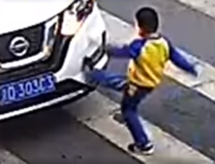 Anak kecil menendang mobil yang tabrak ibunya.