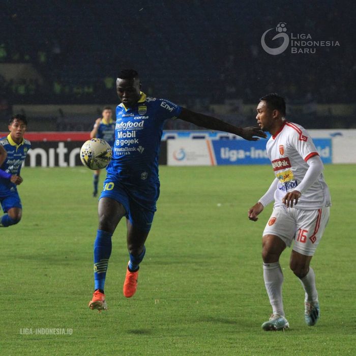 Striker Persib Bandung, Ezechiel N'Douassel (kiri), dijaga ketat pemain Perseru Badak Lampung, Saepulloh Maulana, dalam laga pekan ke-33 di Stadion Si Jalak Harupat, Bandung, Senin (16/12/2019).