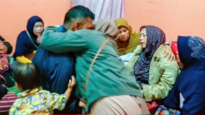 Aiptu Rukur Sidabutar (jaket hitam) dipeluk oleh keluarga saat di rumah duka, Selasa (17/12/2019) malam.