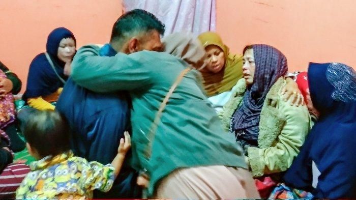 Aiptu Rukur Sidabutar (jaket hitam) dipeluk oleh keluarga saat di rumah duka, Selasa (17/12/2019) malam. Tampak pula istri Aiptu Rukur tersandar di bahu keluarganya sambil menangis tersedu-sedu.