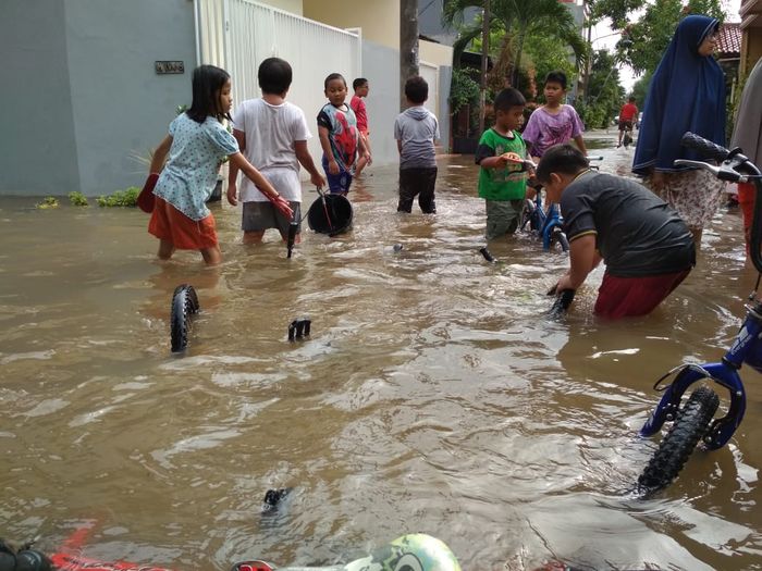 Anak-anak yang bermain saat banjir.