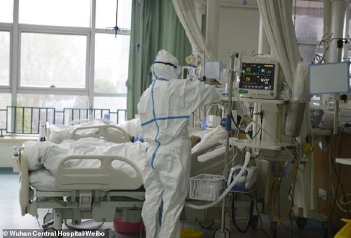  Seorang petugas medis berjas hazmat terlihat sedang memeriksa perangkat medis di dalam unit perawatan intensif rumah sakit