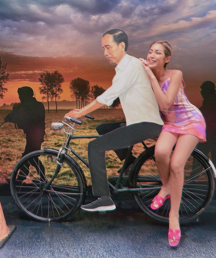 Tampilan Jessica Iskandar saat berpose membonceng sebuah foto Presiden Jokowi