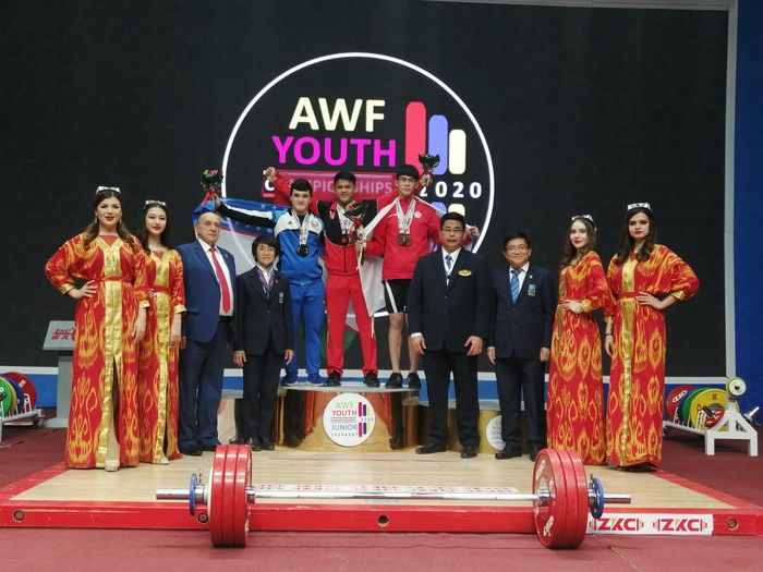 Lifter putra Indonesia, Rizki Juniansyah, berpose setelah meraih medali emas dan memecahkan rekor dunia pada Kejuaraan Angkat Besi Junior Asia 2020 di Sports Complex, Uzbekistan, Minggu (16/2/2020).