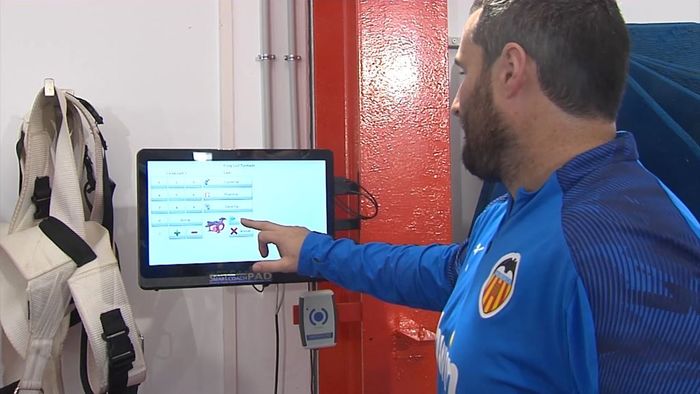Asisten pelatih kebugaran Valencia CF mengoperasikan alat fitness elektronik.