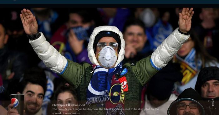 Pendukung Napoli menggunakan masker dalam pertandingan Liga Champions melawan Barcelona di Stadion San Paolo.