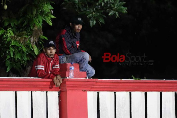 Suporter Persija Jakarta, The Jak Mania, terpaksa menaiki tembok dan pohon untuk menyaksikan pertandingan melawan Bhayangkara FC di Stadion PTIK, Melawai, Jakarta Selatan, Sabtu (14/3/2020)