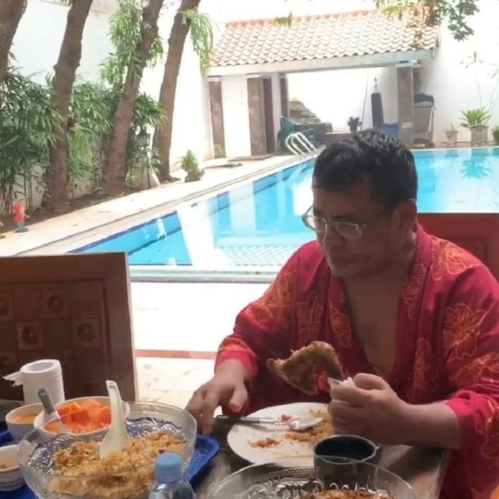 Meja makan yang menghadap kolam renang di rumah