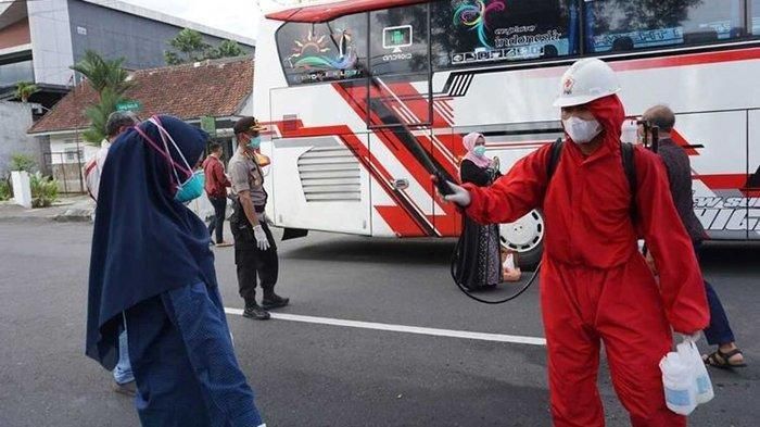 Petugas menyemprot disinfektan kepada tamu hajatan warga di Purwokerto, Jawa Tengah, disemprot disinfektan, Minggu (22/3/2020).