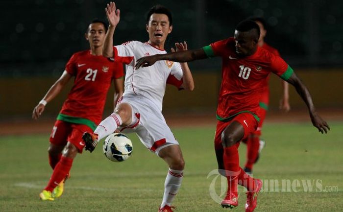 Pemain Timnas Indonesia, Greg Nwokolo (kanan), berebut bola dengan pemain China, Yang Hao, pada pertandingan kualifikasi Piala Asia 2015 di Stadion Utama Gelora Bung Karno (SUGBK), Senayan, Jakarta Pusat, Selasa (15/10/2013) malam. Pertandingan berakhir imbang dengan skor 1-1.
