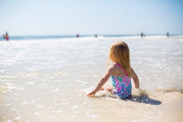 Seorang anak kecil <a href='https://batam.tribunnews.com/tag/berjemur' title='berjemur'>berjemur</a> di pantai.