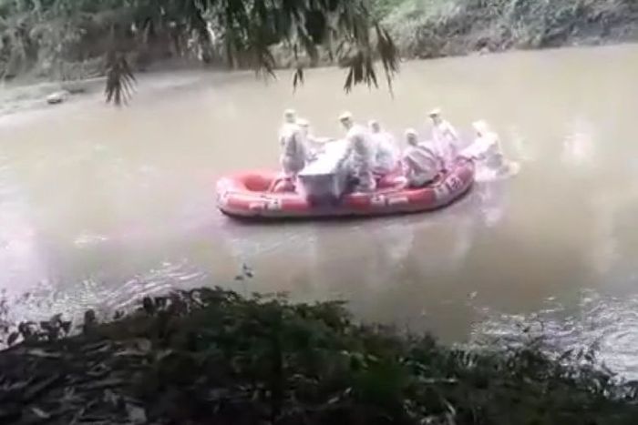 Petugas pengantar jenazah Covid-19 Kota Padang mengantarkan jenazah menyeberangi sungai ke pemakaman, Jumat (17/4/2020) lalu