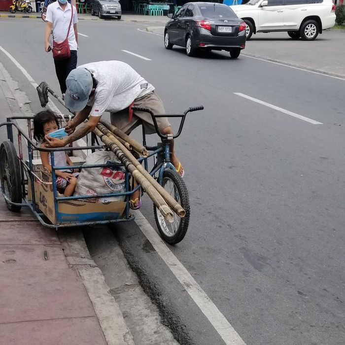 Pemulung ini memberikan masker untuk anaknya.