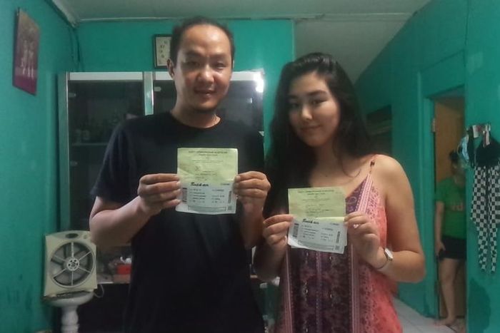 Edo Junaidi (35) dan pujaan hatinya Kurbanbaeva Aiperi (19) yang merupakan warga negara Kyrgyzstan menunjukkan paspor, Rabu (6/5/2020). Selama lockdown, Aiperi tinggal di rumah Edi di Kelurahan Sukaraja.