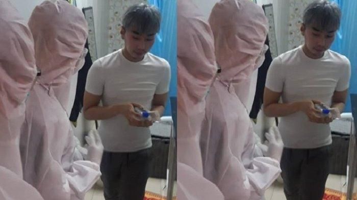 Roy Kiyoshi nampak berjalan sambil ditunggu oleh dua orang yang mengenakan alat pelindung diri (APD) lengkap.