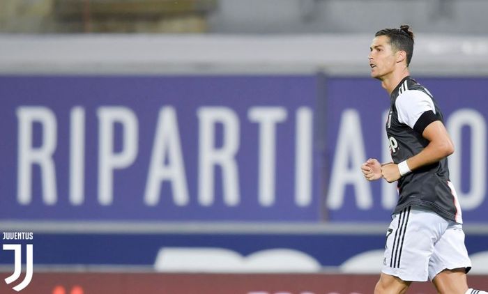 Megabintang Juventus, Cristiano Ronaldo, mencetak gol yang membuat kiper Bologna minggir pada laga Liga Italia di Stadion Renato Dall'Ara, Senin (22/6/2020).
