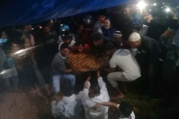 Sejumlah warga di Kota Ambon memakamkan pasien Covid-19 tanpa menggunakan protokol kesehatan, Jumat malam (26/6/2020). Pasien positif berinisial HK tersebut sebelumnya diambil paksa oleh pihak keluarga dari ambulns yang melintas di Jalan Jenderal Sudirman sore tadi.