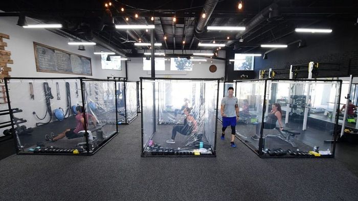 Peet Sapsin memimpin kelas di Inspire South Bay Fitness dengan siswa di belakang lembaran plastik di pod latihan mereka.