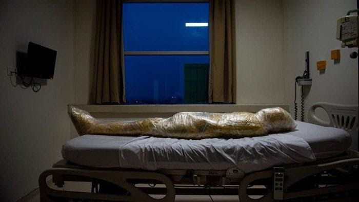 Fotografer National Geographic Joshua Irwandi memotret jenazah pasien Covid-19 yang terbungkus plastik dan terbaring di atas ranjang di salah satu rumah sakit.
