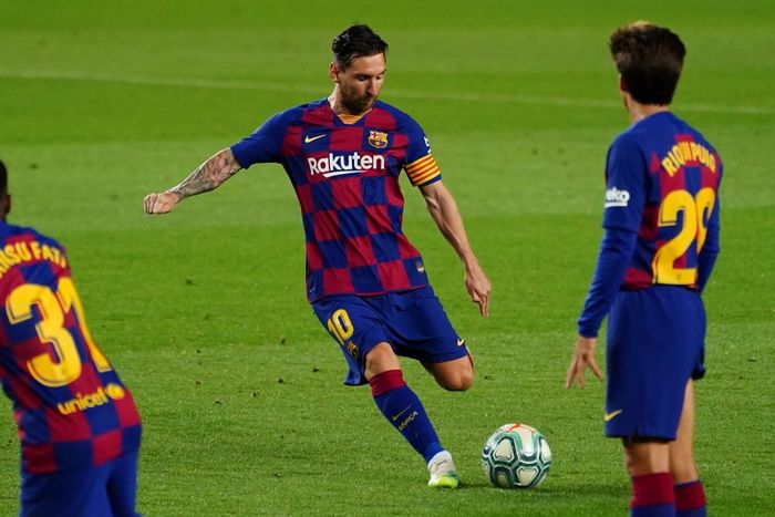 Bintang Barcelona, Lionel Messi, menembak bola dalam pertandingan.